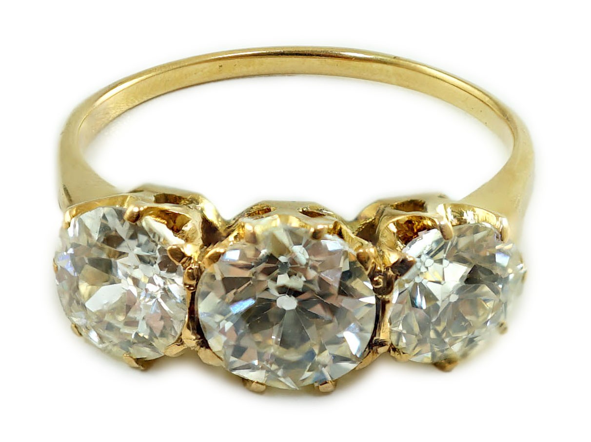 A gold and three stone diamond ring